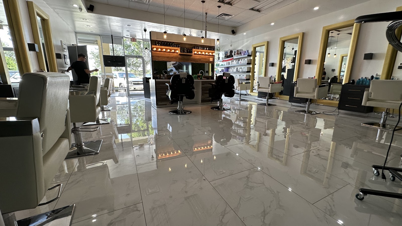 Wide view of the salon floor with styling chairs and marble tile